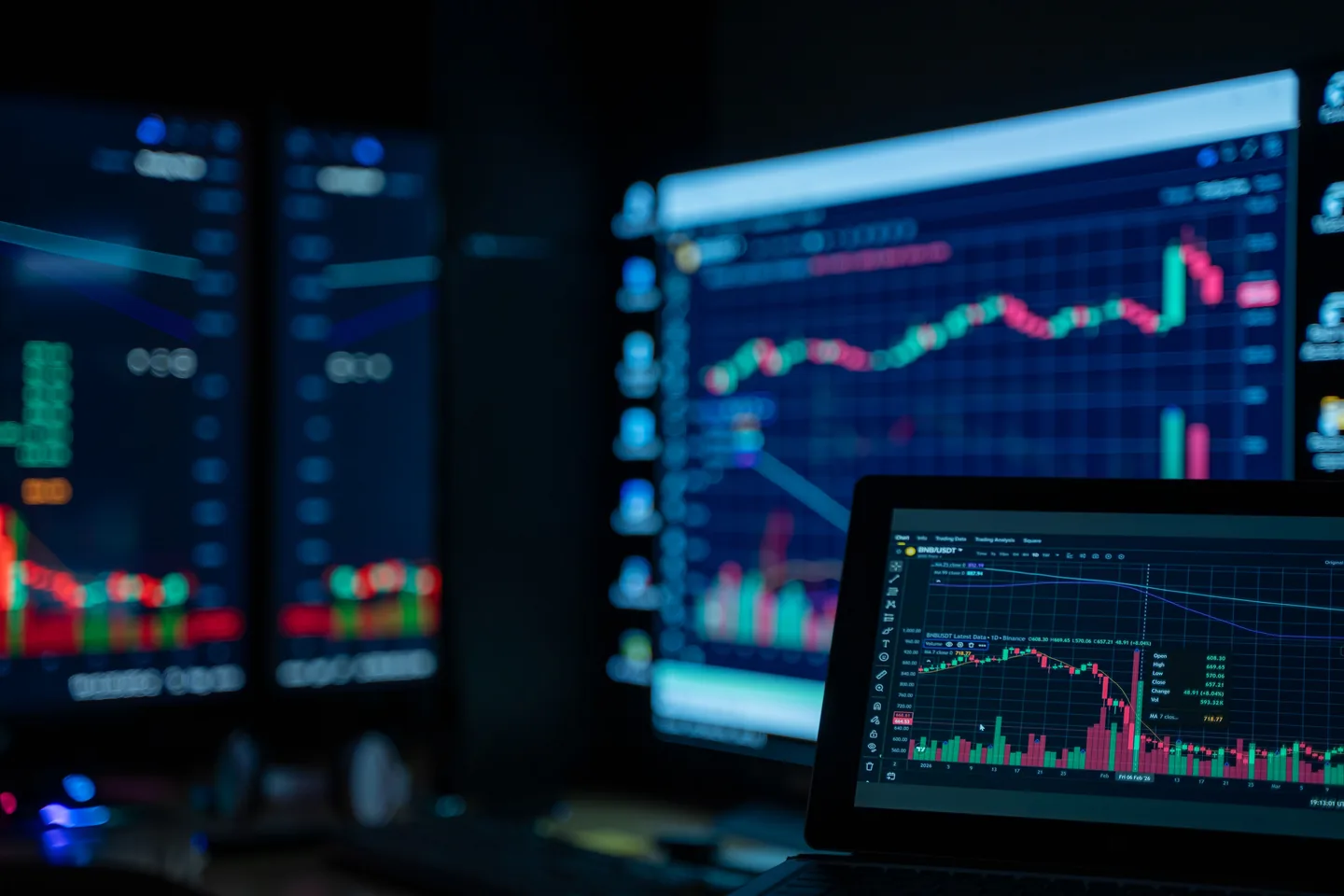 Trading screens showing market data in a darkened room